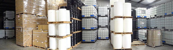 Warehouse stocked with totes, drums, and packaged chemical products